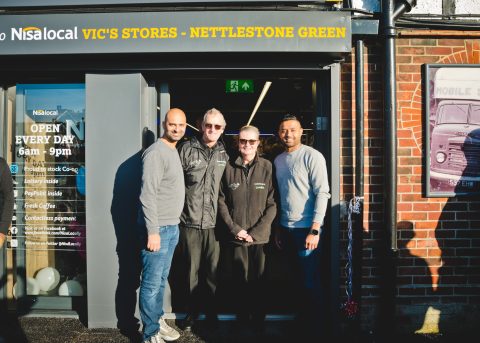 The owners of Vic's Stores standing at the entrance to the shop.